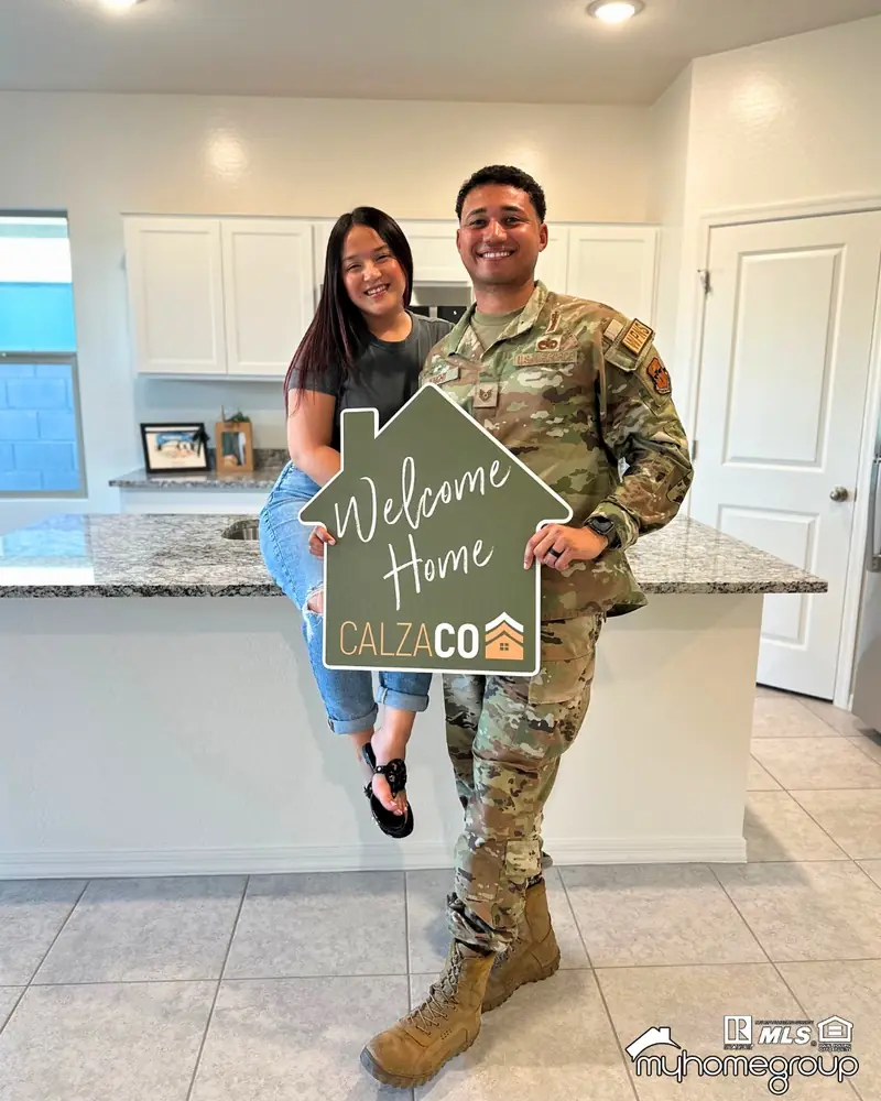 Military couple holding a CalzaCo Welcome Home sign